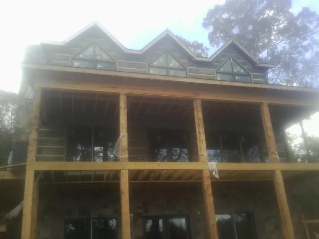 Dormers and porch framing on a large log home under construction — Roof Coating work by our crew in Reelsville